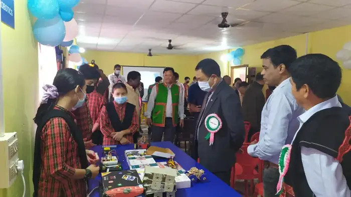 Students showing robotics kits to guests at a school lab event
